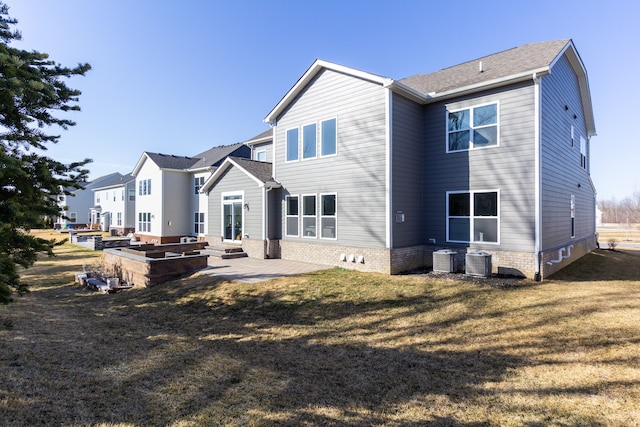 rear view of property with central AC unit, a lawn, and a patio