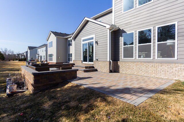 rear view of property with entry steps and a patio