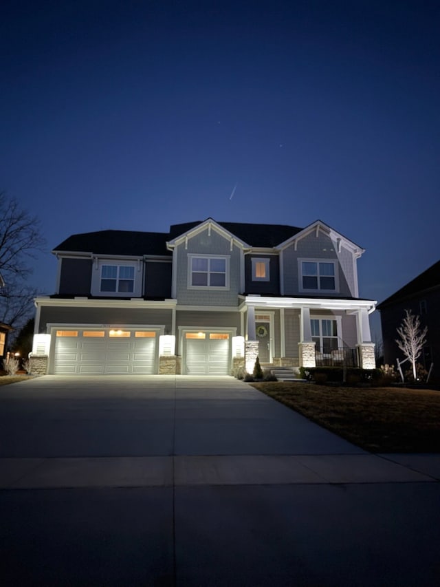 view of front of house with concrete driveway, an attached garage, and a porch