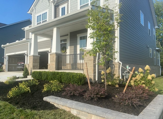 view of home's exterior featuring a porch, concrete driveway, and a garage