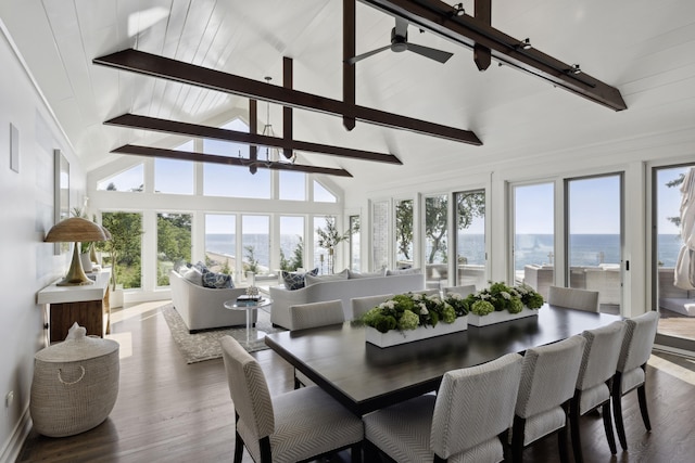 dining area featuring rail lighting, beamed ceiling, dark wood-type flooring, and high vaulted ceiling