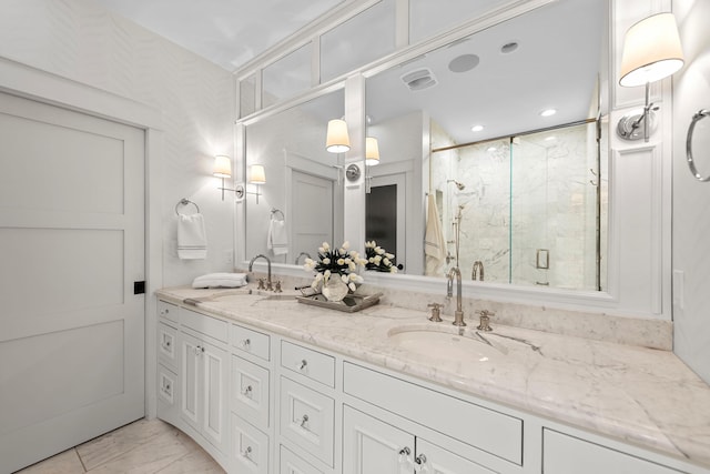 full bathroom with marble finish floor, visible vents, a marble finish shower, and a sink