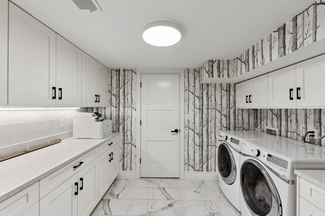 clothes washing area with baseboards, visible vents, cabinet space, separate washer and dryer, and marble finish floor