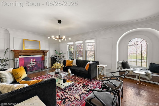 19344 Strathcona Dr, Detroit, MI 48203 - living area with crown molding, healthy amount of natural light, a chandelier, wood finished floors, and a brick fireplace
