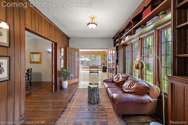 19344 Strathcona Dr, Detroit, MI 48203 - living area with french doors, dark wood finished floors, wooden walls, and a textured ceiling