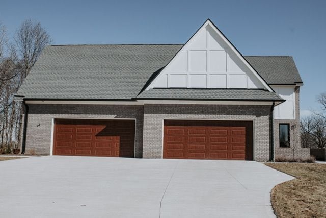 72460 Henry D Dr, Romeo, MI 48065 - view of front of property with brick siding, an attached garage, concrete driveway, and a shingled roof