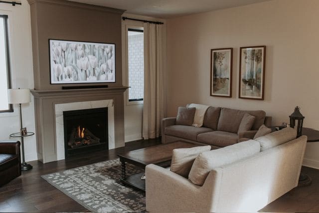 72460 Henry D Dr, Romeo, MI 48065 - living room featuring a wealth of natural light, a warm lit fireplace, and dark wood-type flooring
