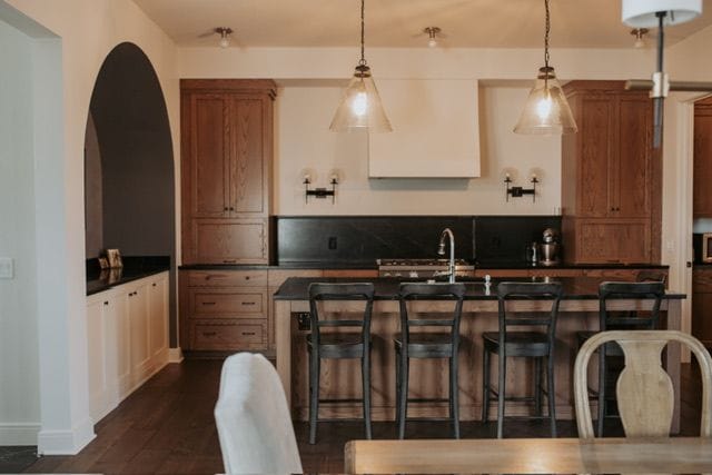 72460 Henry D Dr, Romeo, MI 48065 - kitchen with dark wood-style floors, a breakfast bar, a sink, hanging light fixtures, and dark countertops