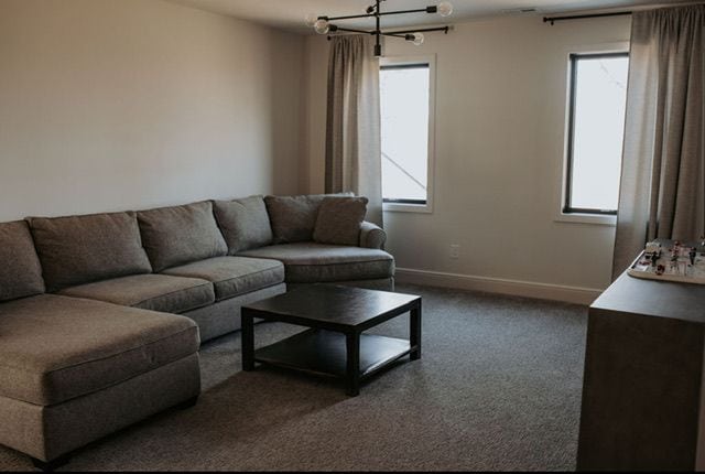 72460 Henry D Dr, Romeo, MI 48065 - carpeted living area featuring a notable chandelier and baseboards