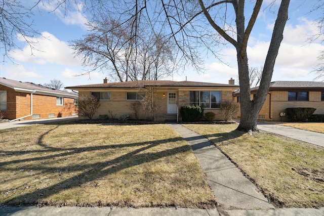 single story home with brick siding, a chimney, and a front lawn