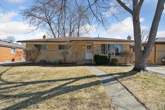 single story home with brick siding, a chimney, and a front yard