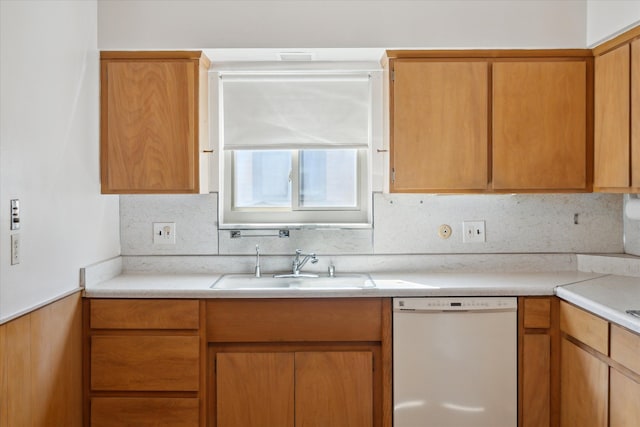 kitchen featuring a sink, tasteful backsplash, dishwasher, and light countertops