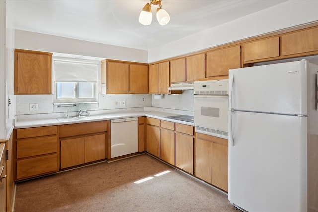 kitchen featuring under cabinet range hood, light floors, light countertops, white appliances, and a sink