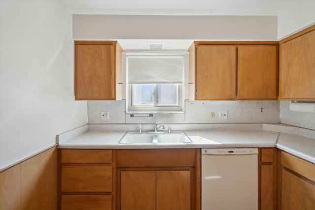 kitchen featuring light countertops, white dishwasher, and a sink