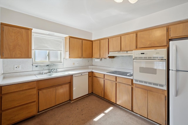 kitchen with under cabinet range hood, white appliances, light countertops, and a sink