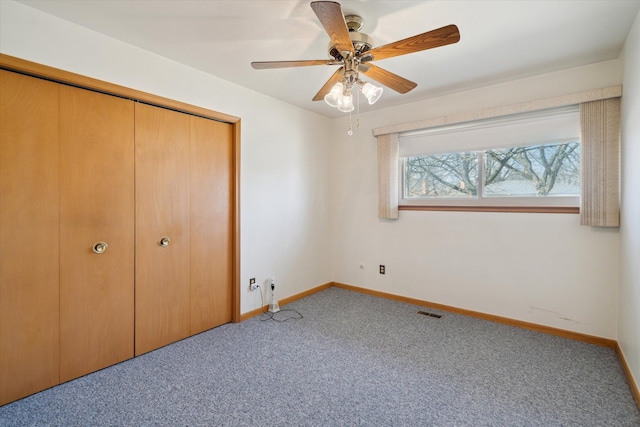 unfurnished bedroom featuring visible vents, baseboards, carpet, a closet, and a ceiling fan