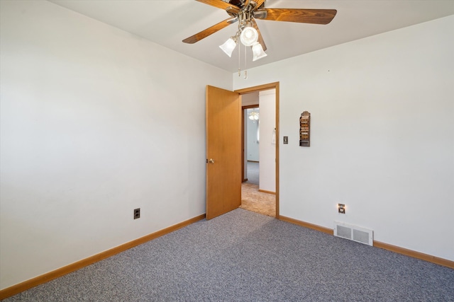 carpeted spare room featuring visible vents, baseboards, and a ceiling fan