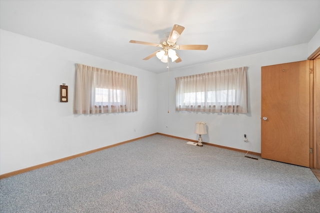 spare room with baseboards, carpet, and ceiling fan