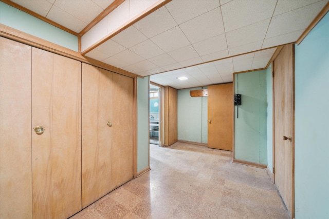 unfurnished bedroom featuring a paneled ceiling and light floors