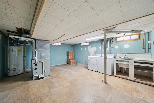 basement featuring gas water heater, heating unit, washing machine and dryer, and tile patterned floors