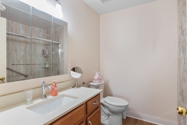 full bath featuring visible vents, baseboards, toilet, a shower with shower door, and vanity