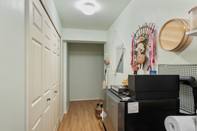 corridor featuring light wood-style floors and baseboards