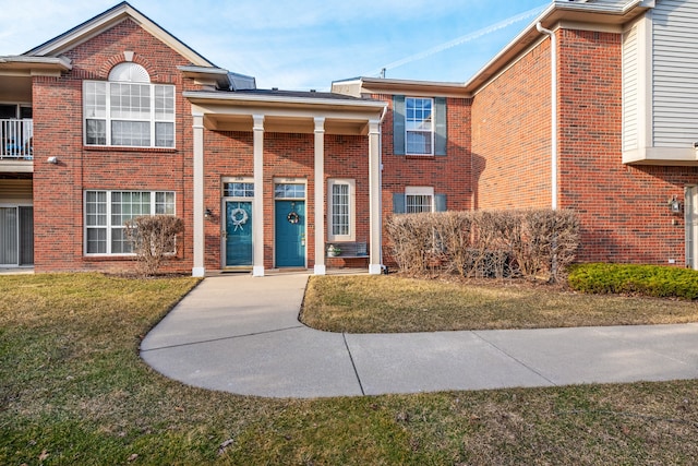 view of front of property featuring brick siding and a front yard