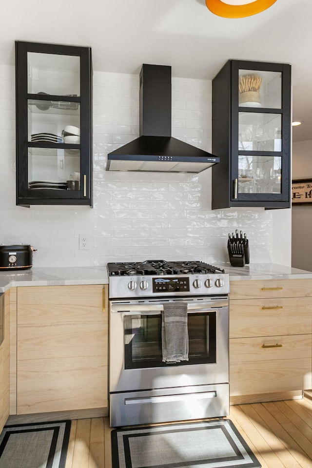 2060 S Algonquin Dr, Benton Harbor, MI 49022 - kitchen with stainless steel gas range, wall chimney range hood, light countertops, and hardwood / wood-style floors