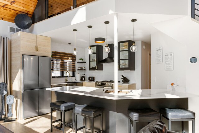 2060 S Algonquin Dr, Benton Harbor, MI 49022 - kitchen with stainless steel appliances, a peninsula, a kitchen breakfast bar, wall chimney exhaust hood, and hanging light fixtures