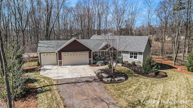 ranch-style house featuring an attached garage, a shingled roof, a front yard, stone siding, and driveway