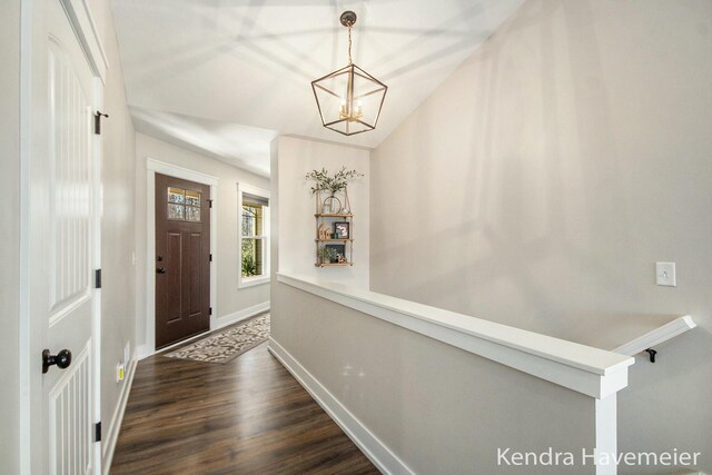 foyer entrance featuring baseboards, an inviting chandelier, and wood finished floors