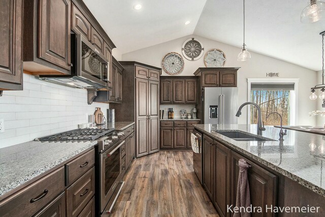 kitchen with a sink, premium appliances, dark wood-style floors, lofted ceiling, and dark brown cabinets