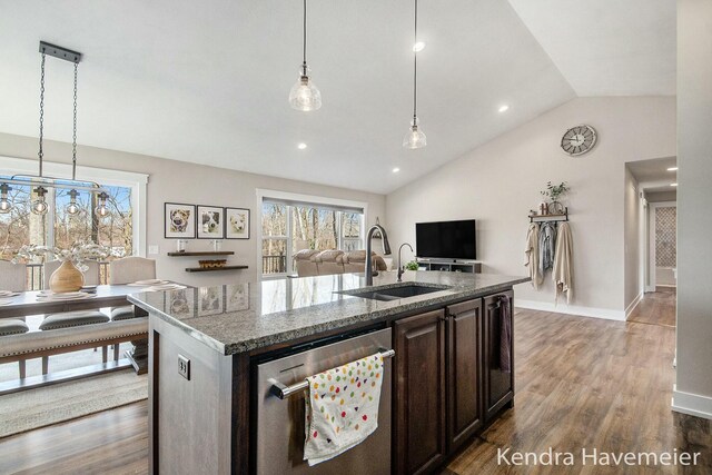 kitchen featuring dark brown cabinetry, stone counters, stainless steel dishwasher, wood finished floors, and a sink