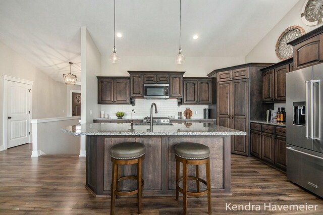 kitchen featuring dark wood finished floors, dark brown cabinets, appliances with stainless steel finishes, and backsplash