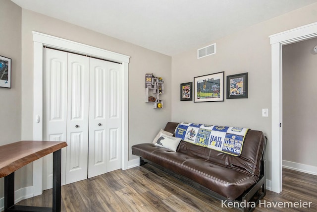 living area featuring visible vents, baseboards, and wood finished floors