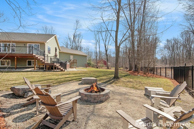 view of yard with stairs, a fire pit, fence, and a wooden deck