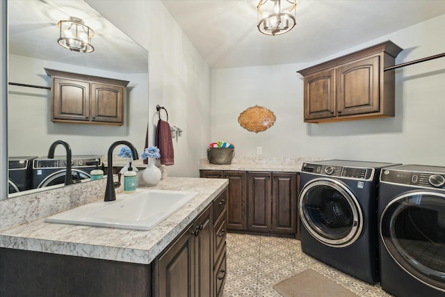 clothes washing area with cabinet space, independent washer and dryer, light floors, and a sink