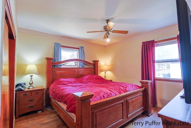 bedroom with crown molding, dark wood-style flooring, and ceiling fan