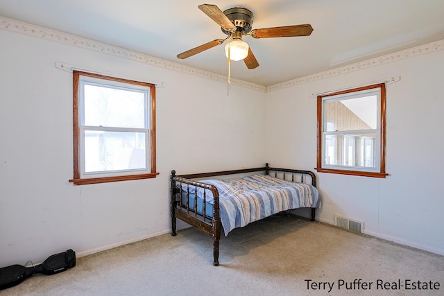 bedroom with visible vents, multiple windows, a ceiling fan, and carpet floors