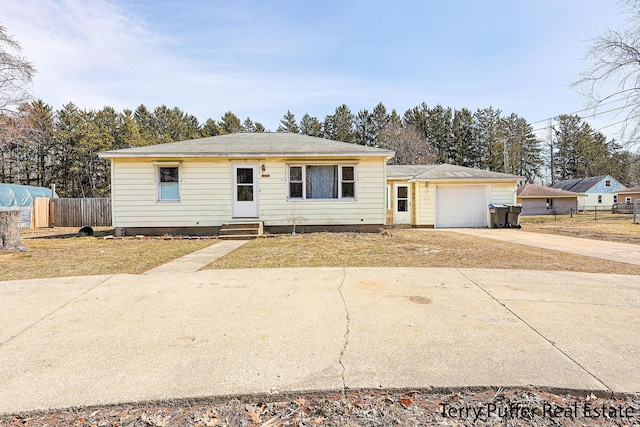 ranch-style home featuring entry steps, concrete driveway, an attached garage, and fence