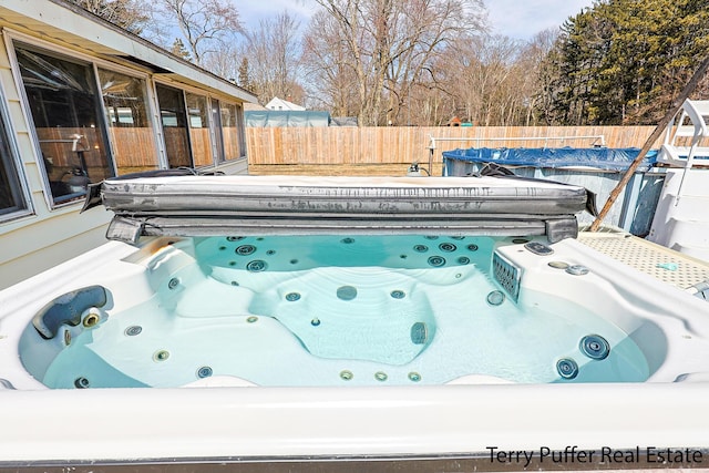 view of pool with a covered hot tub and fence