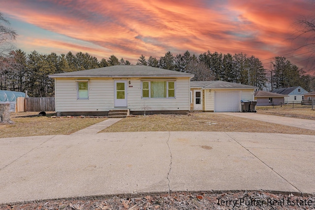 ranch-style home with entry steps, fence, a garage, and driveway