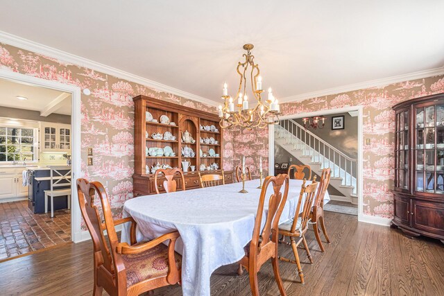 dining space featuring ornamental molding, stairs, wallpapered walls, dark wood finished floors, and a notable chandelier