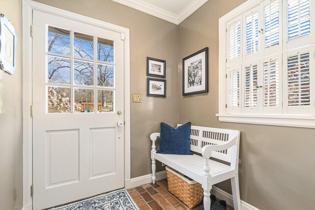 doorway to outside featuring baseboards, ornamental molding, brick floor, and a healthy amount of sunlight