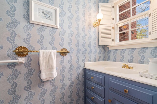 bathroom featuring vanity and wallpapered walls
