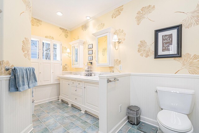 bathroom featuring crown molding, vanity, wainscoting, and toilet