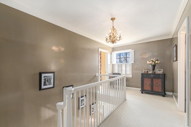 corridor with an inviting chandelier, carpet floors, baseboards, an upstairs landing, and ornamental molding