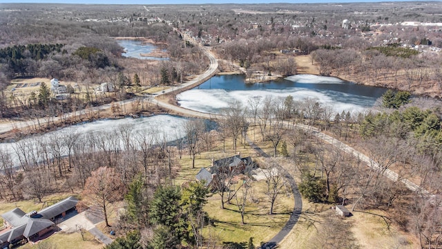 birds eye view of property with a water view and a view of trees
