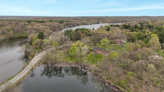 drone / aerial view featuring a water view and a wooded view
