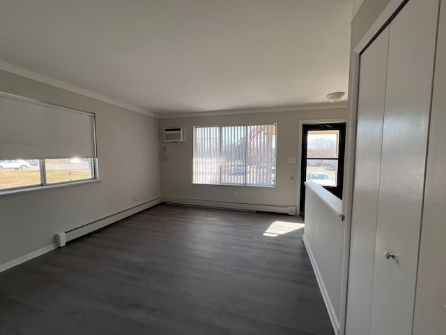 interior space with a wall unit AC, wood finished floors, baseboards, a baseboard heating unit, and crown molding